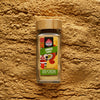 Ceylon ginger powder in a glass jar with ground ginger scattered in the background
