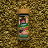 Green cardamom pods in a glass spice jar with single-origin cardamom pods scattered in the background